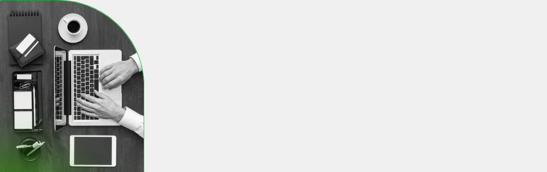 Overhead view of hands typing on a laptop, surrounded by a tablet, notebook, coffee cup, and card reader on a dark desk. The image represents digital work, administration, or online business setup.