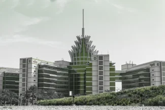 The unique, futuristic central building of Dubai Silicon Oasis (DSO), featuring green architectural highlights and a spire-like roof design.