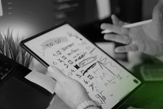 Hands holding a tablet displaying a handwritten To Do list and sketches, suggesting planning, task management, or idea generation.