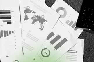 Papers showing data analysis, marketing reports, and a world map, indicating global reach or performance metrics.