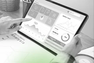 Hand pointing to a digital business dashboard on a tablet showing charts for weekly sales, earnings, and social media analysis.