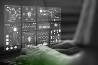 Cybersecurity professional viewing a virtual dashboard with digital locks, security shields, and complex data graphs overlaid on a laptop.