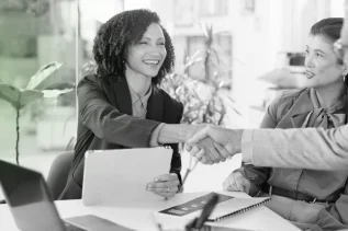 Female executive shaking hands to finalize a local sponsor or partner agreement for an LLC business.