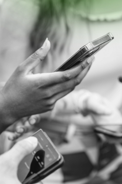 Close-up of multiple people holding smartphones and actively scrolling, highlighting mobile technology and social media engagement.